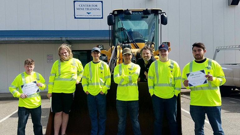 Employees smiling in front of the Center for Mine Training