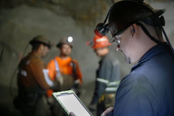 A photo of a miner using a tablet.