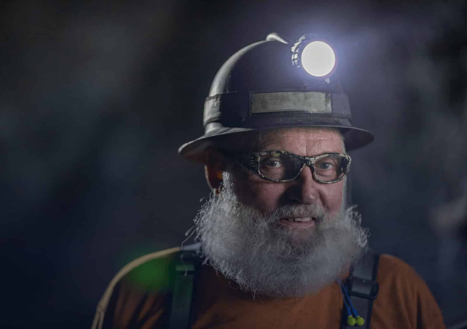 A man with his mining hat light on.