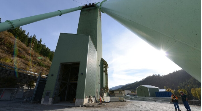 Workers by a green mining building