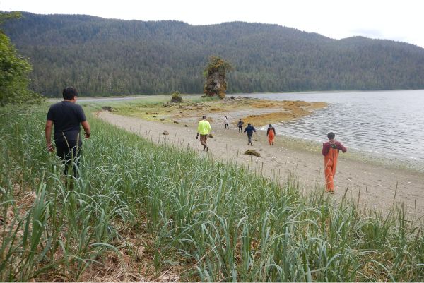 A group of indigenous people by the beach.