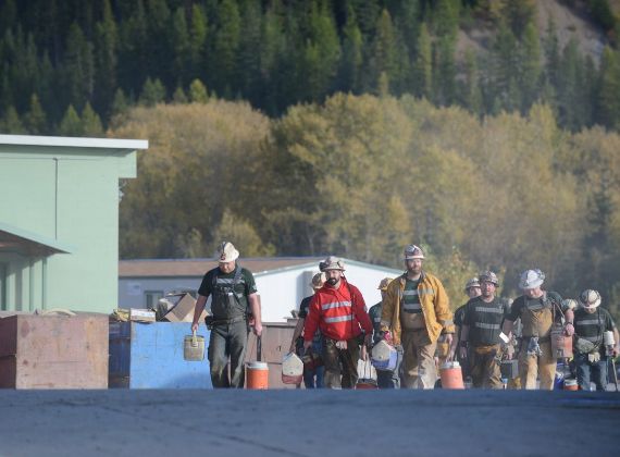 A group of miners carrying something while walking.