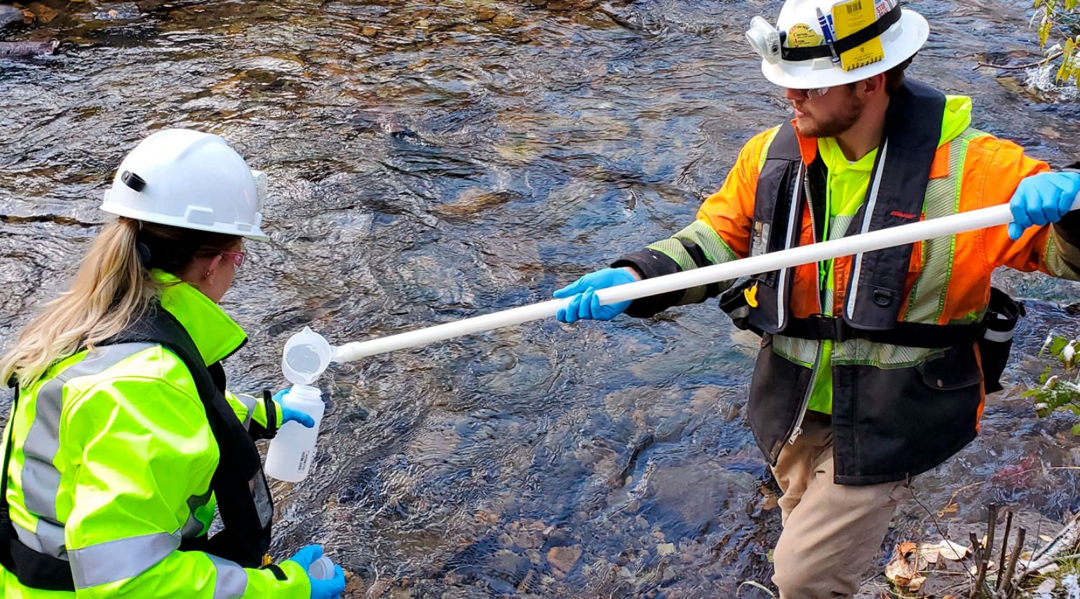 A photo of two workers testing the water quality.