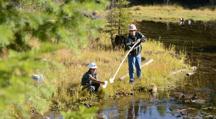 Two construction workers doing water monitoring.