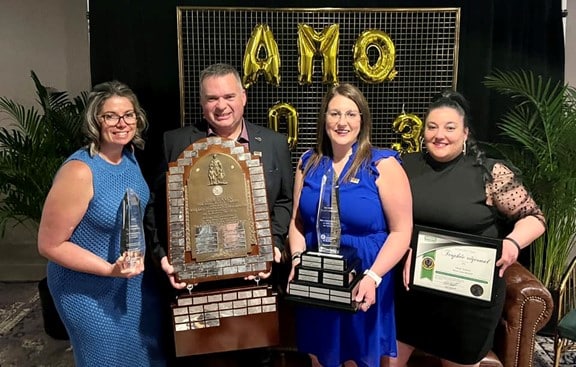 Group shot of people holding multiple awards